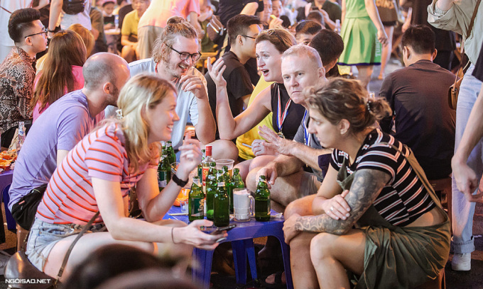 Foreigners drink beer at Ta Hien backpacker area in Hanoi's Old Quarter, 2022