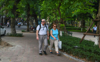 Foreigners walk on a street in Hanoi's Old Quarter