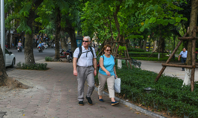 Foreigners walk on a street in Hanoi's Old Quarter